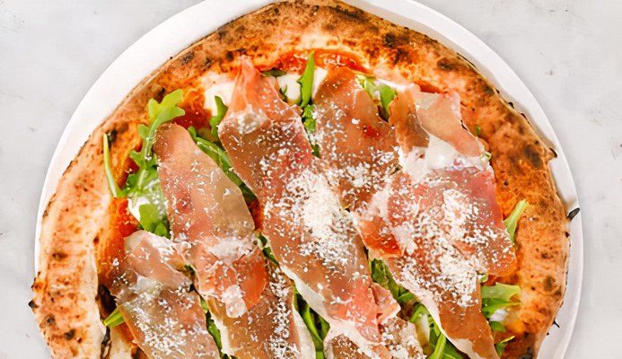 Marketing photo of a margherita prosciutto pizza.
